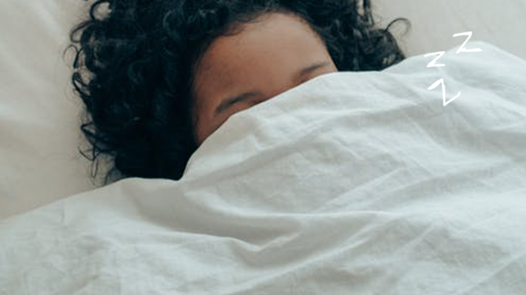 person covering eyes with duvet to try to sleep better, be better