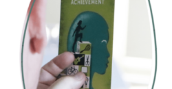 Person holds a card that reads 'Achievement'