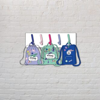 Three rucksacks in lilac, light green and blue hang on colourful pegs against a white wall backdrop.
