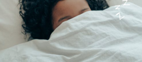 person covering eyes with duvet to try to sleep better, be better
